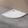 A white corner shower tray with a silver drain is placed on a concrete floor against a tan wall. Produktbild-Vorschau