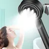 A woman is showering with a black shower head that is spraying water. Produktbild-Vorschau