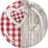 A round plate or lid with a rustic design featuring a red and white gingham heart on a wooden background. Produktbild-Vorschau