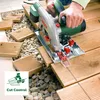 A person is using a Bosch circular saw to cut wooden planks for a deck, with gravel and other planks visible in the background. Podgląd zdjęcia produktu