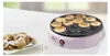 A pink poffertjes maker with poffertjes on a plate next to it. Anteprima dell’immagine prodotto
