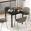 A square black dining table with four gray chairs set up in a dining area. Podgląd zdjęcia produktu