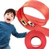 A young boy is excitedly playing with a toy car race track. Podgląd zdjęcia produktu