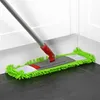 A mop head with green chenille fibers is cleaning a dark tiled floor in the corner of a room, near a white baseboard and wall. Produktbild-Vorschau