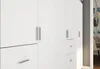A close-up view of a white modular wardrobe with silver handles and drawers. Podgląd zdjęcia produktu