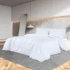 A white duvet set is laid out on a bed in a modern bedroom setting. Produktbild-Vorschau