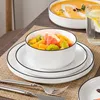 A table setting with a fruit salad in a bowl, a glass of water with lemon, and a bowl of soup. Náhled obrázku produktu