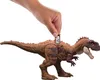 A hand is placing a small tag with a QR code onto the back of a toy dinosaur. Produktbild-Vorschau