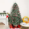 A decorated Christmas tree with presents underneath, next to a fireplace and a chair. Produktbild-Vorschau