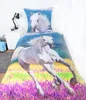 A bed with a duvet cover and pillow featuring a white horse running through a field of purple flowers. Produktbild-Vorschau