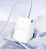 A white USB-C charger is placed on a snowy, icy surface with a white cable plugged into it. Produktbild-Vorschau