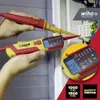 A close-up shot of hands holding two Wiha voltage testers, one of which is being used to test electrical connections in a panel. Náhľad obrázku produktu