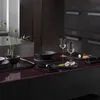 A dark, modern kitchen counter with a set table. Náhľad obrázku produktu
