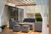 An outdoor patio lounge set with a sofa, chairs, ottomans, and a coffee table, set under a pergola with string lights. Náhled obrázku produktu