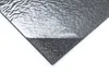 A close-up view of a sample of self-adhesive carpet tiles, showing the anthracite needle felt surface and a peeled-back corner revealing the silver backing. Produktbild-Vorschau