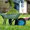 A person is dumping grass clippings into a wheelbarrow in a yard. Voir les images du produit