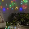 An outdoor evening setting with string lights, drinks, and plants. Produktbild-Vorschau
