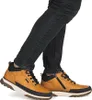A person wearing black jeans and brown boots. Voir les images du produit