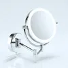 A close-up, studio shot of a silver LED cosmetic mirror mounted on a wall. Produktbild-Vorschau