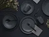 A flat lay of dark gray stoneware dinnerware set on a black surface, with dried flowers as decoration. Náhľad obrázku produktu