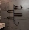 A black heated towel rack mounted on a tiled wall next to a wooden vanity. Náhľad obrázku produktu