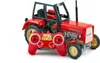 A red toy tractor with a remote control in front of it, on a white background. Náhľad obrázku produktu