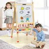 Two children are interacting with a wooden easel in a room. Produktbild-Vorschau