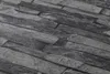 A close-up view of a textured wallpaper with a stone brick pattern. Náhľad obrázku produktu