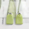 Close-up of two green fabric tie-backs for curtains, attached to metal grommets on transparent curtains with text printed on them. Produktbild-Vorschau