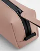 A close-up view of a pink accessory case with a black zipper. Voir les images du produit