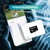 A hand holding a smartphone displaying a security camera app, with a MicroSD card in the foreground. Produktbild-Vorschau