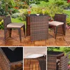 A patio furniture set with a table and two chairs on a wooden deck, with a garden in the background. Anteprima dell’immagine prodotto