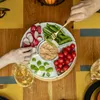 A top-down view of a serving platter filled with vegetables and dip, with hands reaching for the food and a glass of white wine on the side. Náhled obrázku produktu