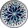 A top-down view of a ceramic plate with a blue floral design. Voir les images du produit