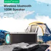 A portable Bluetooth speaker is placed on rocks in front of a tent with a mountain landscape in the background. Podgląd zdjęcia produktu