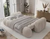 A modern bedroom with a unique, plush beige sofa bed. Produktbild-Vorschau