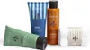 A set of men's grooming products including face wash, aftershave lotion, shower gel, and a towel, arranged on a white background. Produktbild-Vorschau