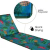 A close-up view of a beach mat with a tropical fruit and leaf pattern, highlighting its material and quick-drying feature. Produktbild-Vorschau