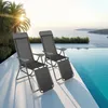 Two lounge chairs are placed on a white patio next to a swimming pool with a view of the ocean. Voir les images du produit