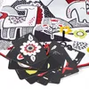 A close-up view of a baby playmat with attached sensory cards and a teether. Podgląd zdjęcia produktu