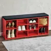 A red shoe rack with a black upholstered top, filled with various shoes and a handbag. Produktbild-Vorschau