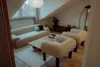 A cozy living room with a sofa, armchairs, and a coffee table. Produktbild-Vorschau