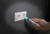 A hand is using a voltage tester to check an electrical outlet. Voir les images du produit