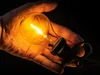 A hand holding a lit light bulb. Anteprima dell’immagine prodotto
