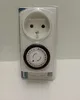 A white mechanical timer plug with a black dial is shown against a white background. Produktbild-Vorschau