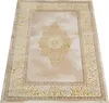 A close-up, angled view of a rectangular rug with a classic golden beige design. Produktbild-Vorschau
