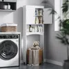 A white bathroom cabinet with storage shelves and doors, placed next to a washing machine in a laundry room. Náhled obrázku produktu