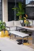 An outdoor seating area with a sofa, bench, and table, decorated with plants and lanterns. Produktbild-Vorschau