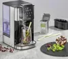A CASO HW 1660 Turbo hot water dispenser is shown in use, dispensing hot water into a glass with tea leaves and herbs. Other items like a tea tin, pomegranate, and mint leaves are also present. Anteprima dell’immagine prodotto
