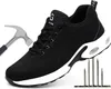A black safety shoe with a white sole, shown with a hammer and nails to demonstrate its protective features. Produktbild-Vorschau